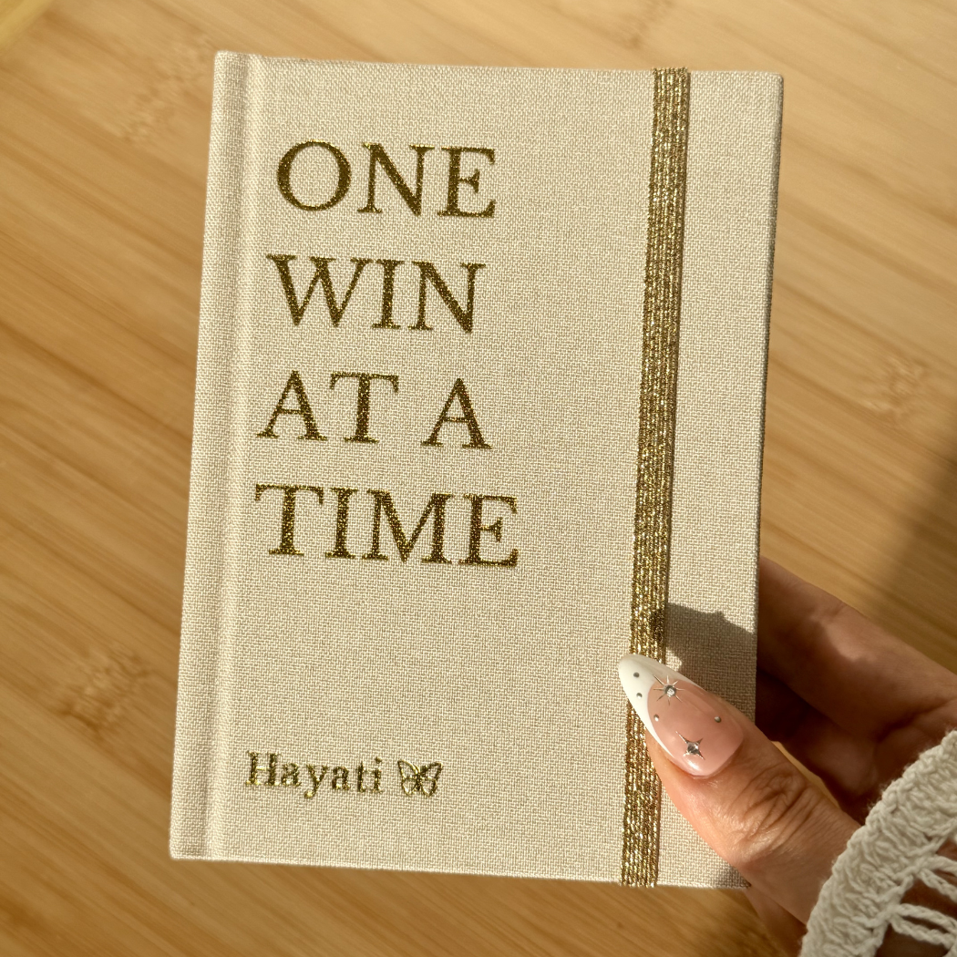 Inwords Gifting One Win at a Time notebook with a motivational cover design featuring inspiring typography and vibrant colors.