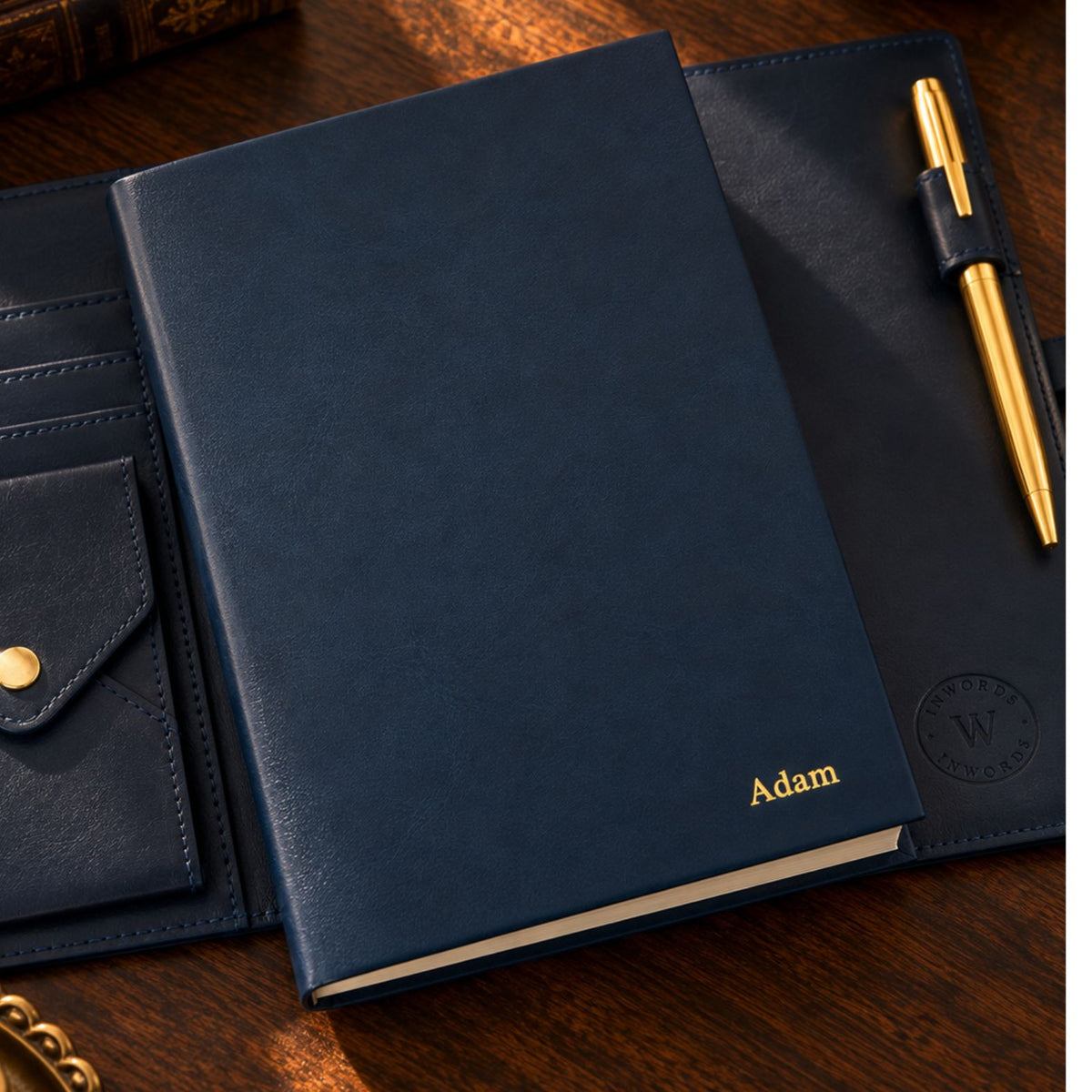 Navy blue Mémoire journal by Inwords Gifting, featuring a hardcover with gold embossed lettering and lined pages inside.